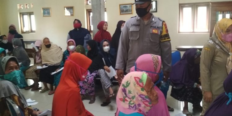 Pak Bhabin Woro-Woro Prokes ke Warga yang sedang Antri BLT DD